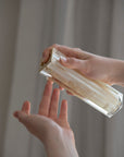 Person holding a rectangular crystal object against a neutral background