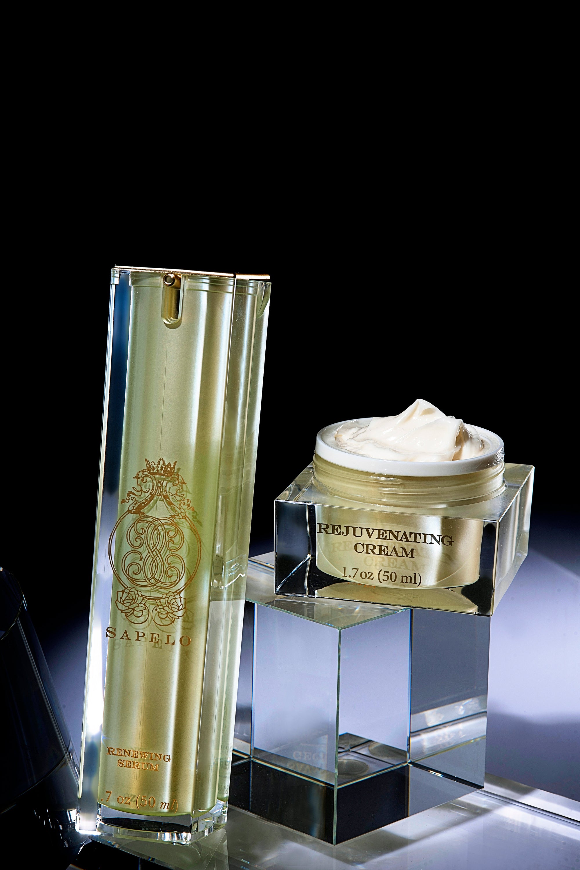 Skincare products including a bottle and jar on a reflective surface with a dark background