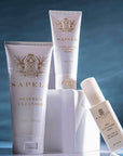 Sapelo skincare products including cleanser, eye cream, and serum on a reflective surface with a blue gradient background.