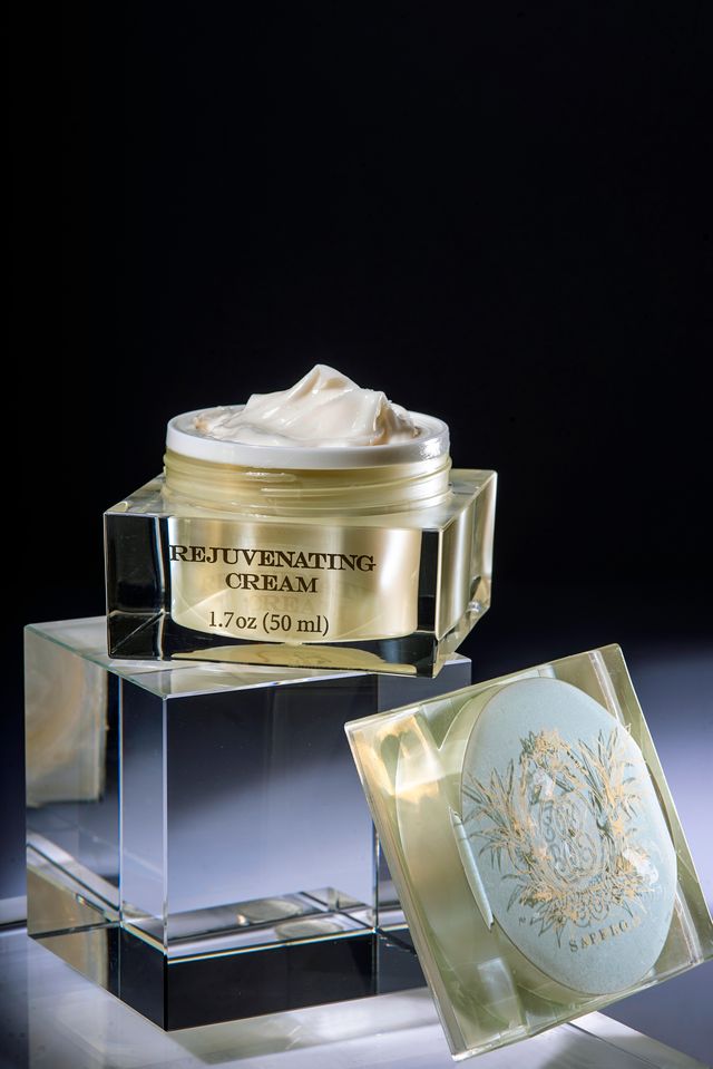 Rejuvenating cream jar with decorative lid on a reflective surface