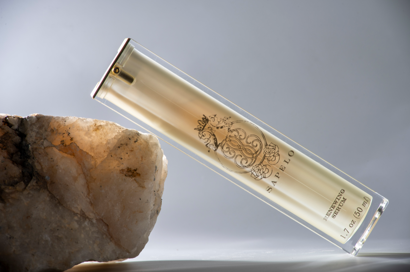 renewing serum with a decorative label on a stone surface