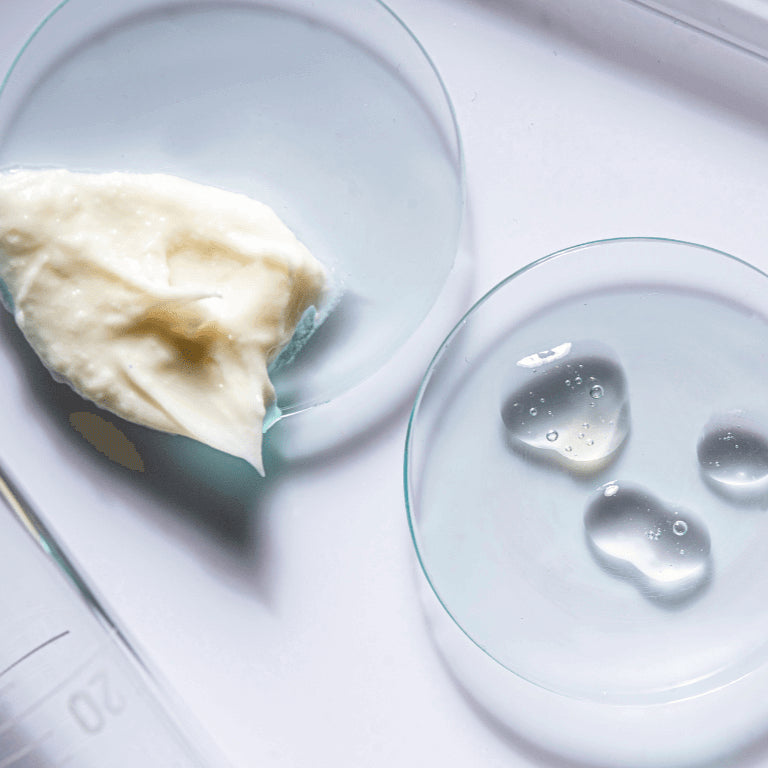 Close-up of a spoon with creamy substance and small droplets on a white background