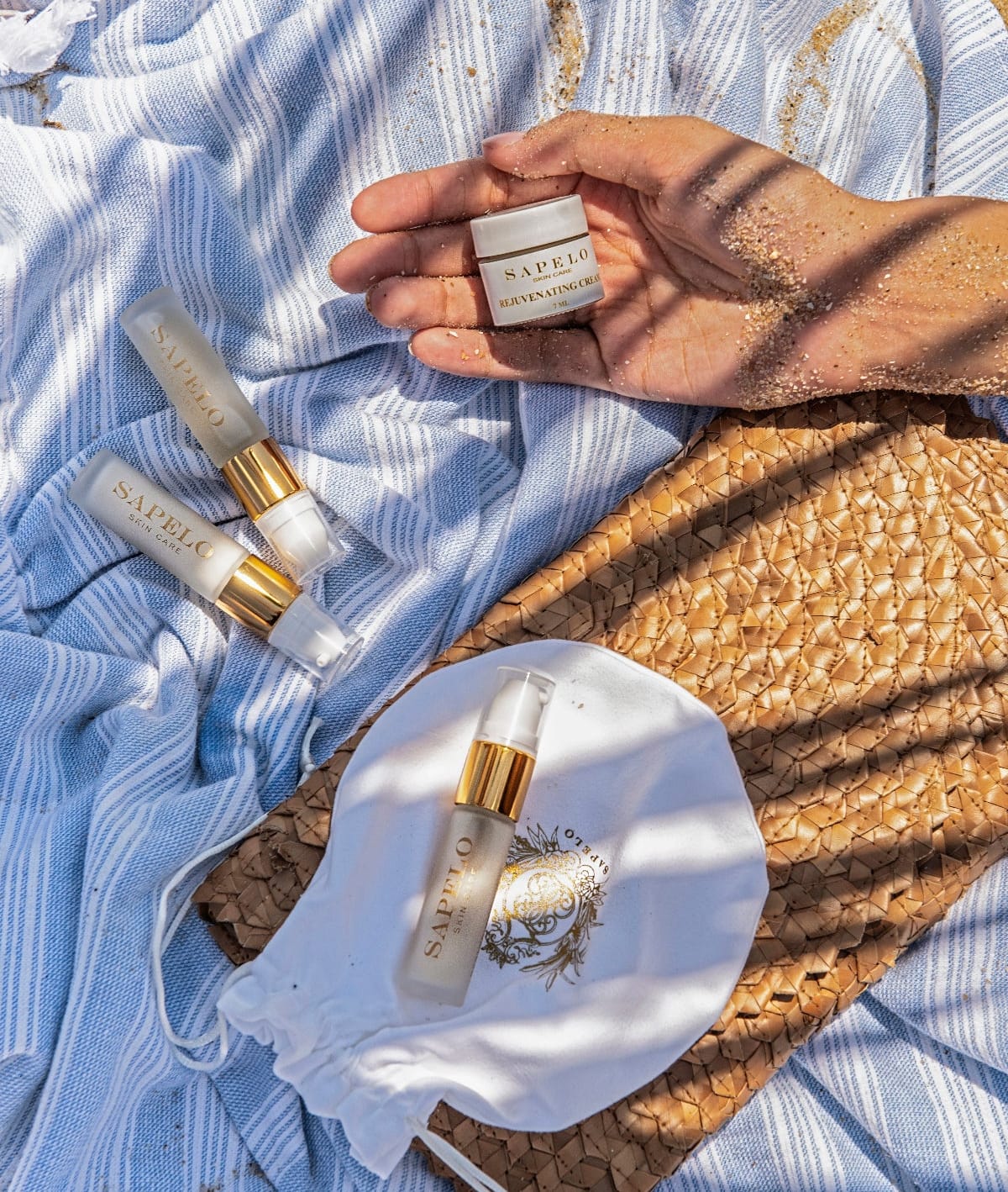travel kit sapelo  skincare products on a textured surface with a blue towel and woven mat.