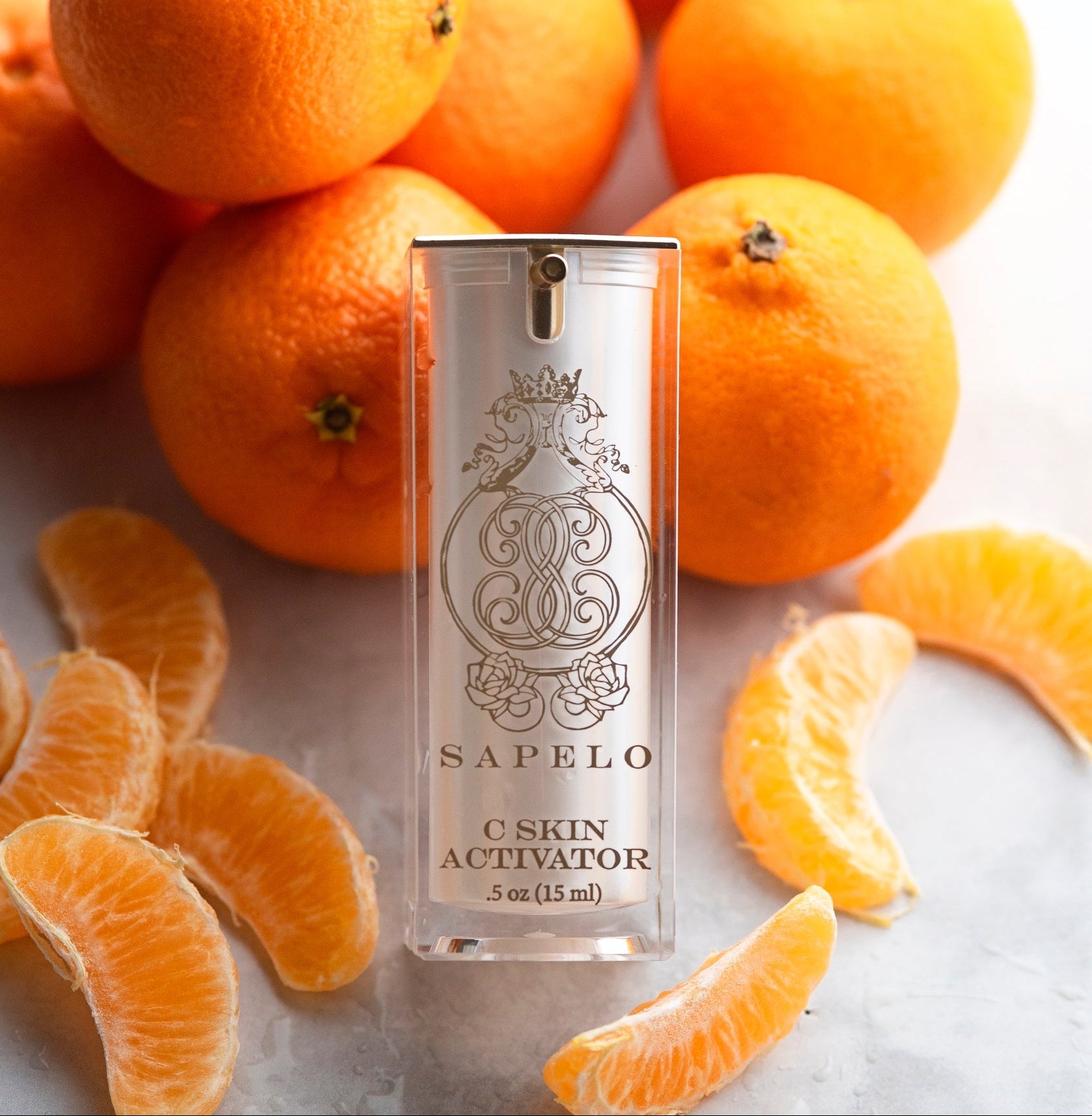 Sapelo C Skin Activator skincare product surrounded by oranges on a light background